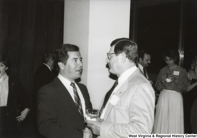 Congressman Nick Rahall II (left) speaking with an unidentified man at his birthday part.