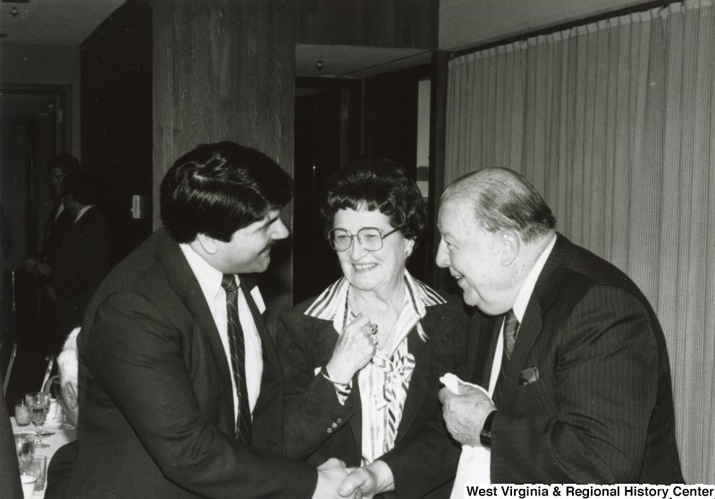 Senator Jennings Randolph (right) shaking the hand of Richard Trumka, President of the United Mine Workers of America (UMWA), at Congressman Nick Rahall's birthday party. An unidentified woman is standing between Randolph and Trumka.