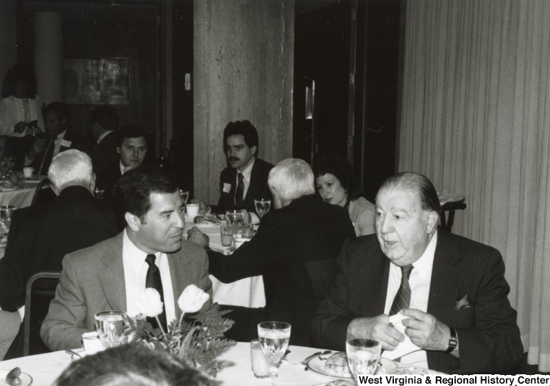 Congressman Nick Rahall II (left) eating with Senator Jennings Randolph (right) at Rahall's birthday party.
