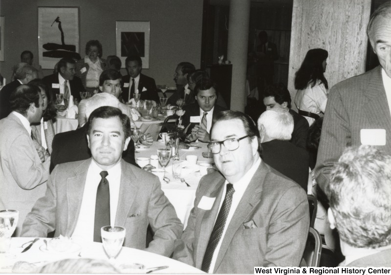 Congressman Nick Rahall II (left) eating with an unidentified man at his birthday party.