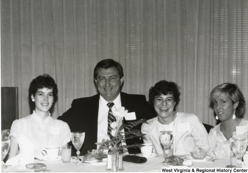 Three unidentified women and one unidentified man eating at Congressman Rahall's birthday party.