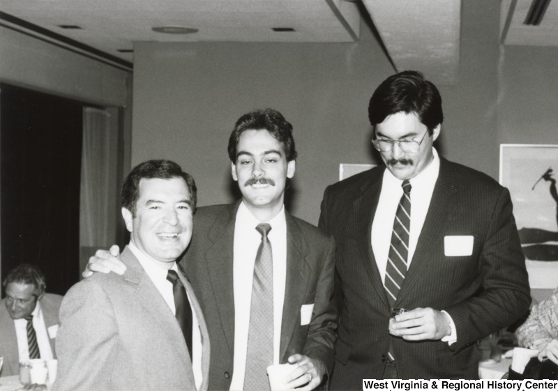 Congressman Nick Rahall II (left) with two unidentified men at his birthday party. The unidentified man in the middle has his arm around Rahall's shoulder.