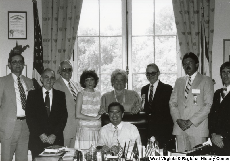 Congressman Nick Rahall II (seated) with an unidentified group of people in his office.
