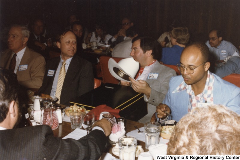 From left to right: Jim Nichols; Norman Roberts; Congressman Nick Rahall II;  and S/Sgt. Ezell "Mac" McKinney eating at Cattlemen's Steak House in Ft. Worth, Texas. Congressman Rahall is holding a cowboy hat.