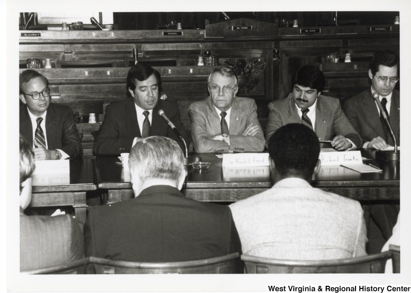 From left to right (facing camera): unidentified man; Congressman Nick Rahall II; Senator Wendell Ford; Richard Trumpka, President of United Maine Workers Association (UMNWA); an unidentified man. Three unidentified men are sitting across from them.Congressman Nick Rahall speaking to a group of men during a meeting.