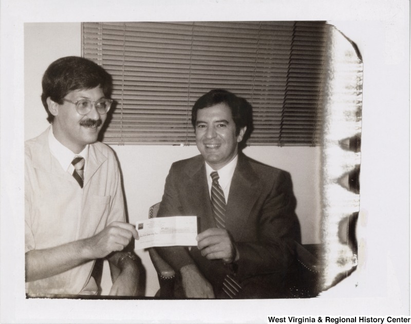 Congressman Nick Rahall, II with an unidentified man. Both are holding the ends of a check.