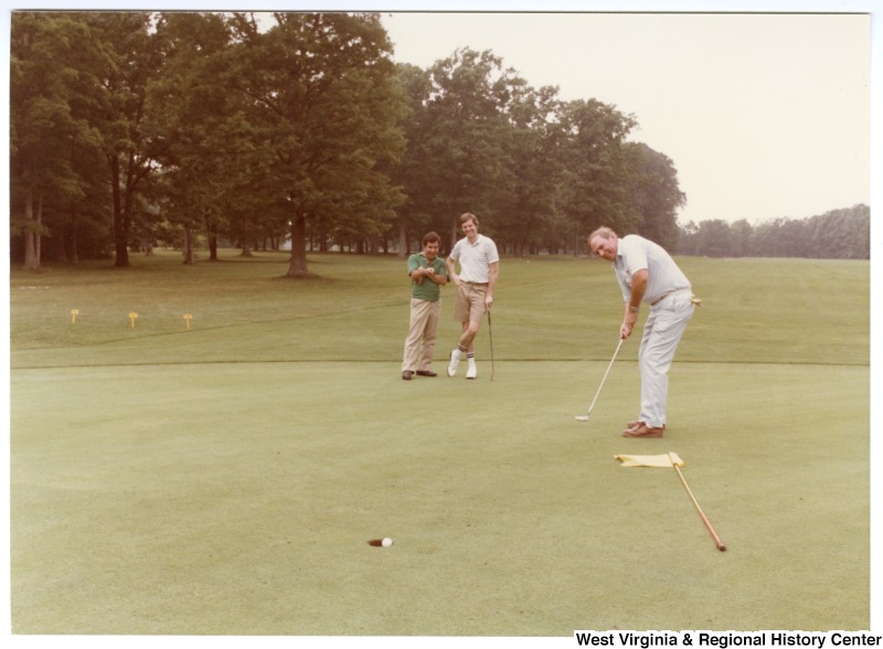 Congressman Nick Rahall, II (left) with two unidentified men golfing at the 1984 Congressional Golf Tournament.