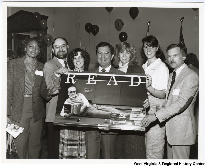 Congressman Nick Rahall, II (center) with an unidentified group of people holding a poster of Paul Newman at the American Library Association's Legislative Day.