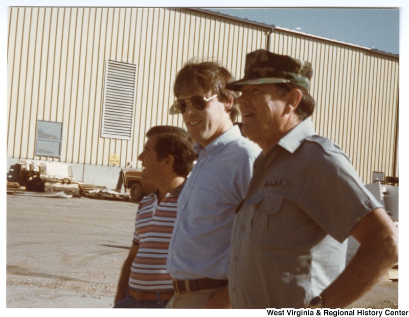 Congressman Nick Rahall, II (left) and two unidentified people standing at an airport.