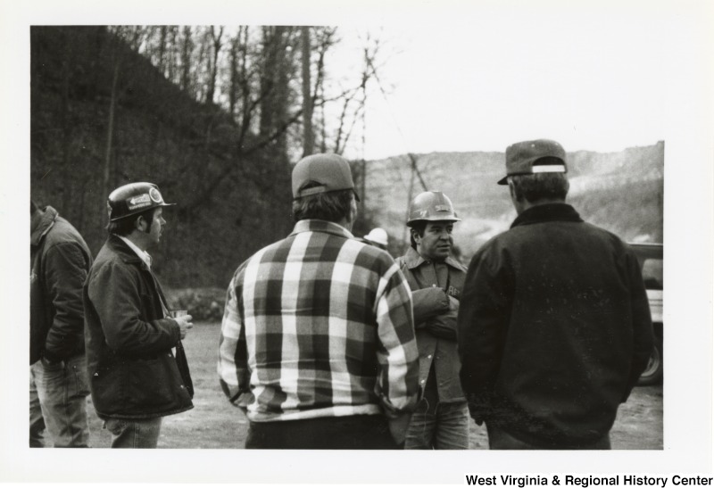 Congressman Nick Rahall, II (second from right) speaking with three unidentified men at the Hobet Coal Mine.