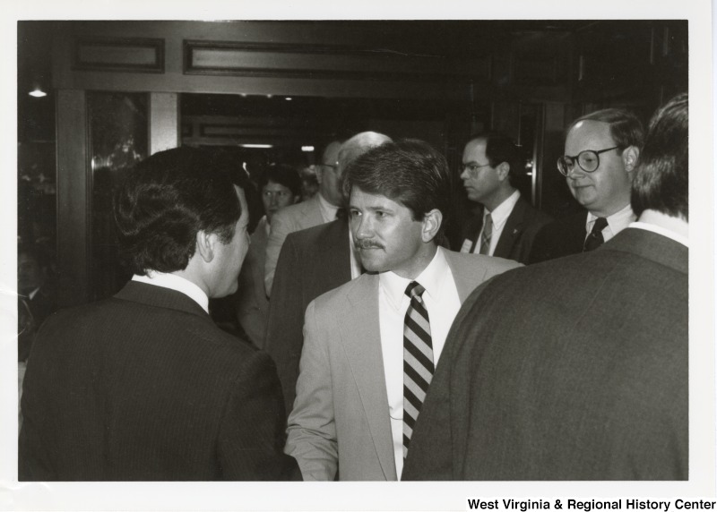 Congressman Nick Rahall II (back turned to camera on left) shaking the hand of an unidentified man.