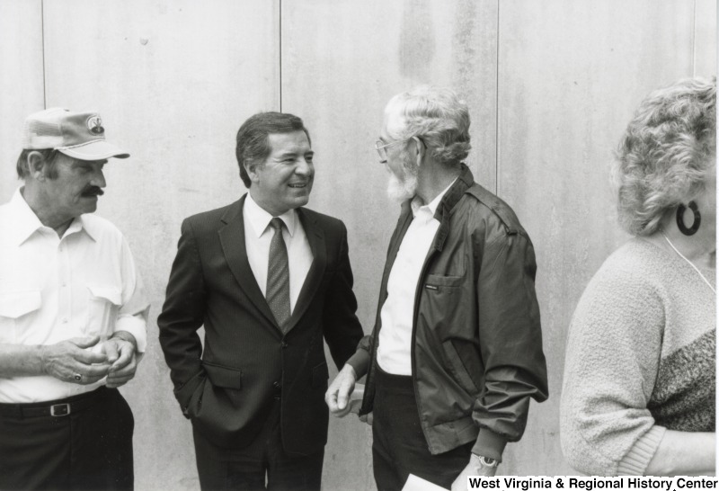 Congressman Nick Rahall, II (center) speaking to two unidentified men at Marshall University.