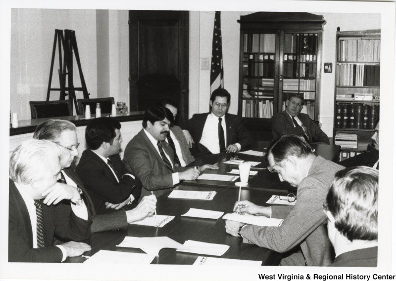 L-R around the table: An unidentified man, Representative Tom Bevill (D-Ala.), Representative Nick Rahall (D-W.Va.), Richard Trumka, president of the United Mine Workers of America (UMWA), an unidentified man, Representative Alan Mollohan (D-W.Va.), Representative John Murtha (D-PA), and an unidentified man. Congressmen from the Congressional Coal Group seated around a table.