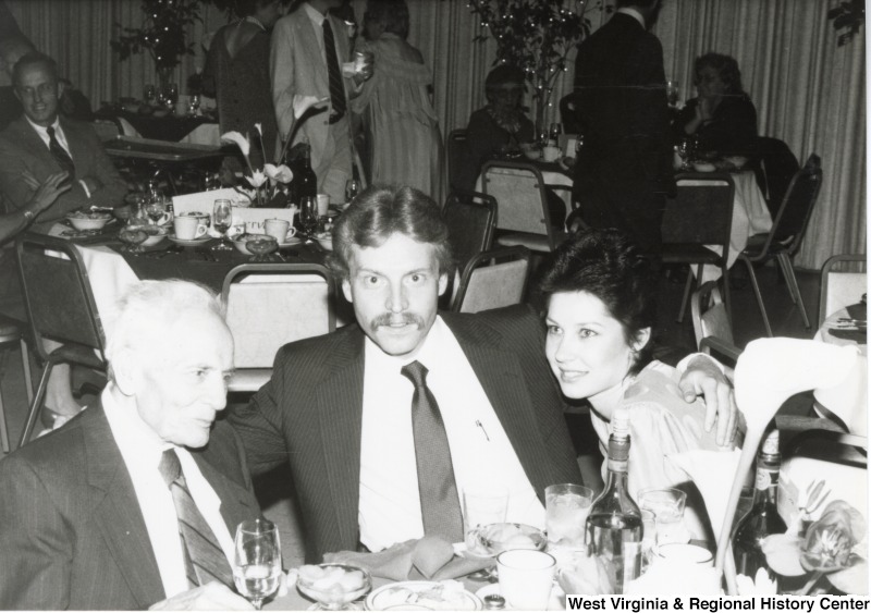 Two unidentified men and an unidentified woman seated at a dining table at the American Lebanese Syrian Associated Charities (ALSAC) dinner.