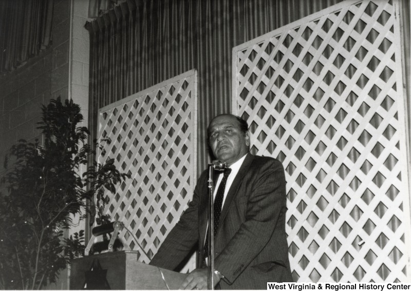 Al Joseph stands and gives a speech from a podium at the American Lebanese Syrian Associated Charities (ALSAC) dinner.