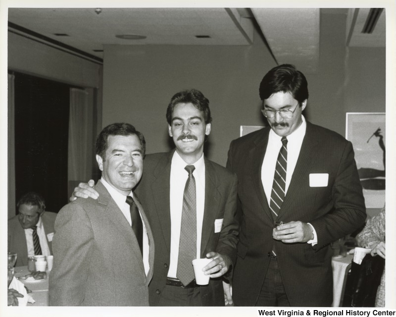 Representative Nick J. Rahall on the left pictured with two unidentified men in a dinner setting.