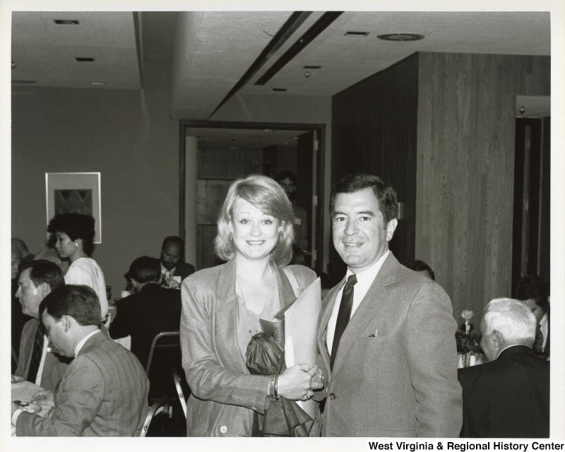 Representative Nick J. Rahall (D-W.Va.) stands next to an unidentified woman for a photo at a dinner.