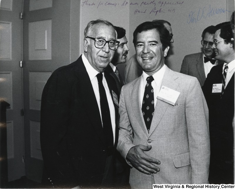 Representative Nick J. Rahall (D-W.Va.)  with an unidentified man associated with the American Diabetes Association. Representative Alan Mollohan (D-W.Va.) stands off to the side talking with three other unidentified men.