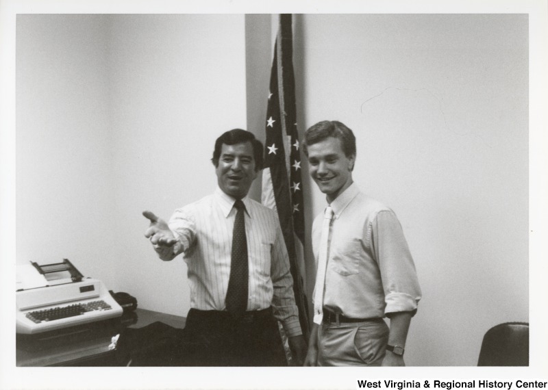 Representative Nick J. Rahall (D-W.Va.) stands next to an unidentified man in front of an American flag.