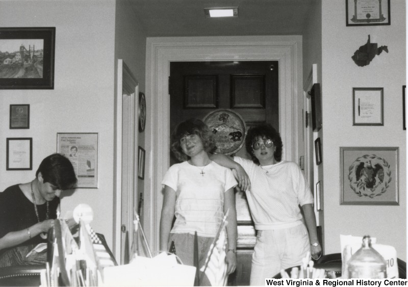 Two unidentified  women stand in the doorway of an office.