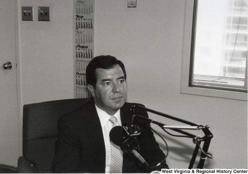 Representative Nick J. Rahall (D-W.Va.) seated in front of a microphone.