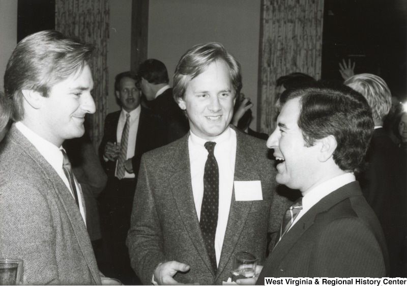 On the far right, Representative Nick J. Rahall (D-W.Va.) speaks with two unidentified men.