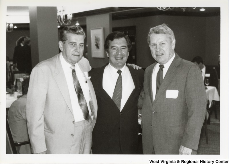 Representative Nick J. Rahall (D-W.Va.) smiles for a photograph standing between two unidentified men.