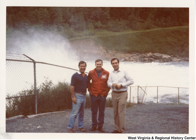 On the left, Representative Nick J. Rahall (D-W.Va.) with two unidentified men in front of a river.