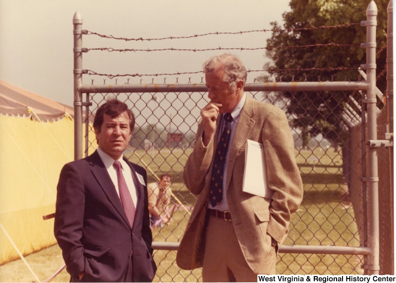 On the left, Representative Nick J. Rahall (D-W.Va.) talks with an unidentified man outside.