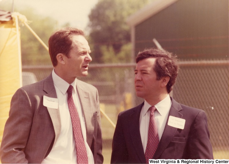 On the right, Representative Nick J. Rahall (D-W.Va.) talks with an unidentified man outside.