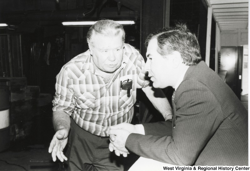 On the right, Representative Nick J. Rahall (D-W.Va.) tlaks with an unidentified man.