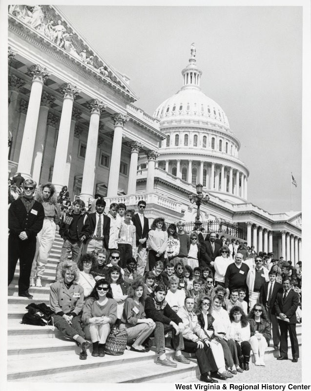 On the far right, Representative Nick J. Rahall (D-W.Va.) stands with an unidentified group of school students in front of the United States Capitol building.