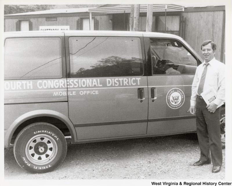 Representative Nick J. Rahall (D-W.Va.) stands beside a van that has on it "Fourth Congressional District Mobile Office United States Congress."