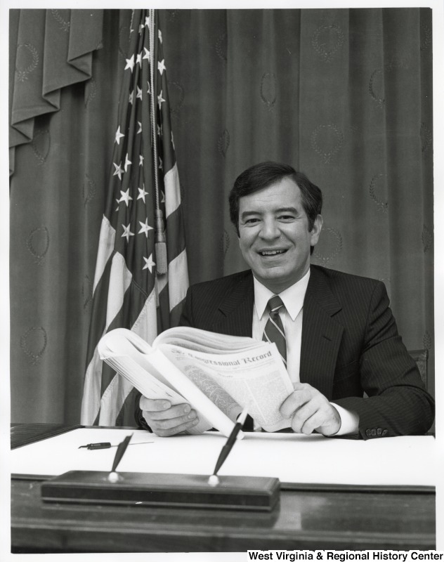 Representative Nick J. Rahall (D-W.Va.) reads "Congressional Record" behind a desk.