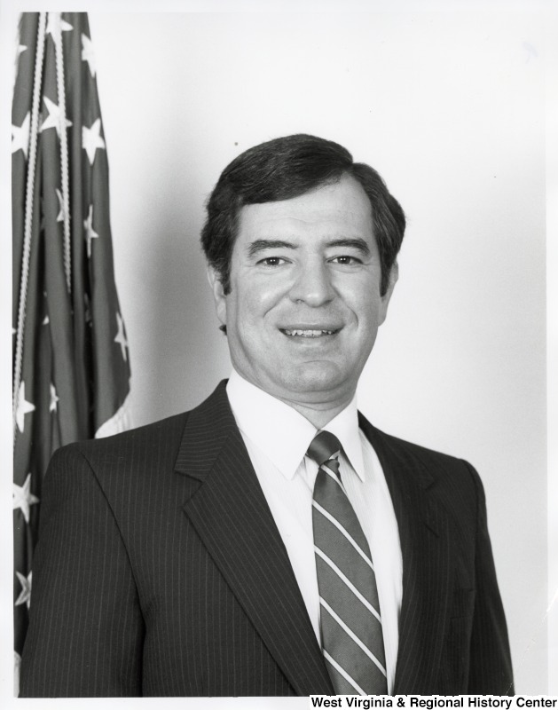 Representative Nick J. Rahall (D-W.Va.) stands for a photograph beside an American flag.