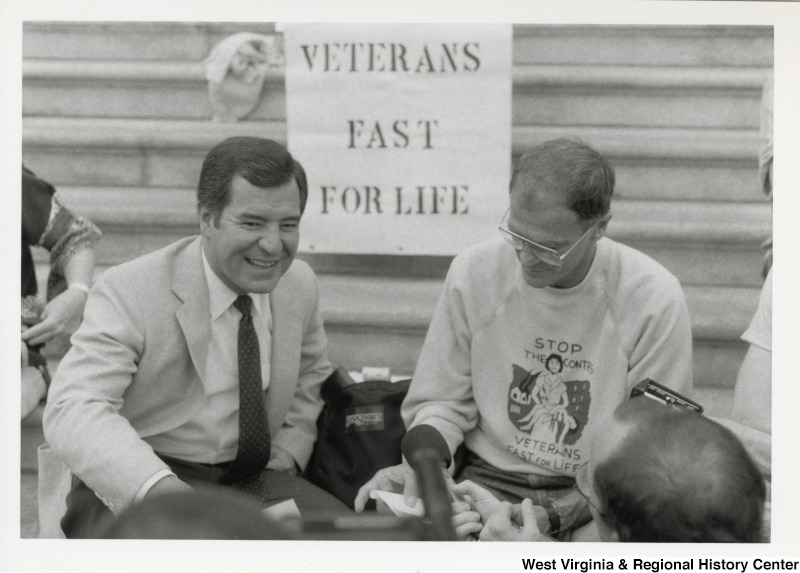 Representative Nick J. Rahall (D-W.Va.) sits on the steps of the Capitol building with an unidentified man as a part of the Veterans Fast for Life.