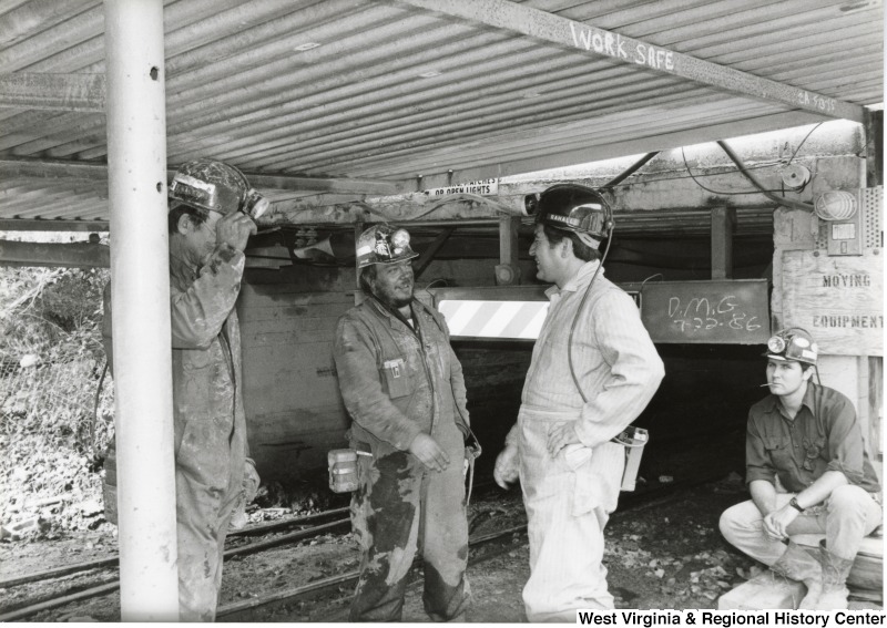 Congressman Nick Rahall dressed in a coal mining uniform with three unidentified coal miners at Old Ben Coal Mine.