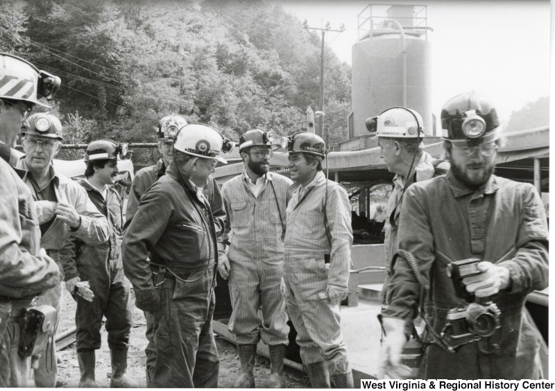 Congressman Nick Rahall dressed in coal miner uniform at Old Ben Coal Mine with eight unidentified coal miners.