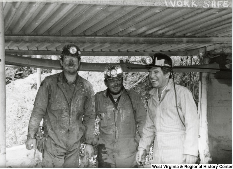 Congressman Nick Rahall dressed in a coal miner uniform at Old Ben Coal Mine with two unidentified coal miners.