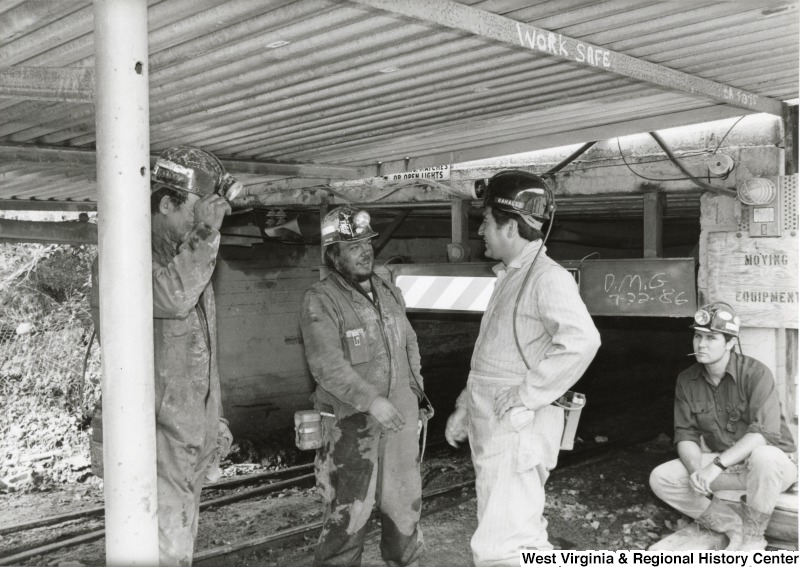 Congressman Nick Rahall dressed in a coal miner uniform at Old Ben Coal Mine with three unidentified coal miners.