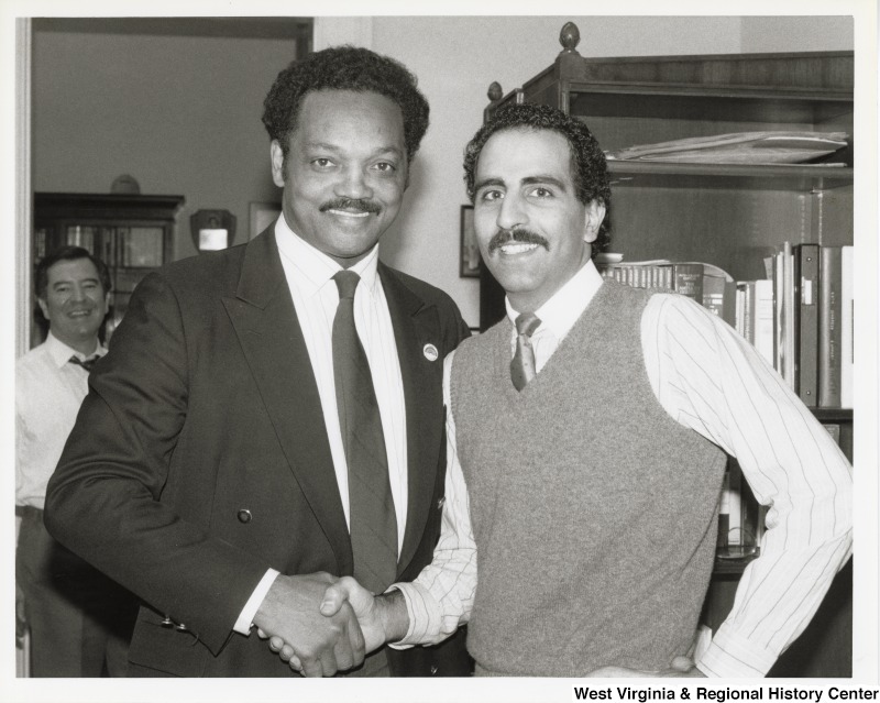 Jesse Jackson, then candidate for the Democratic presidential nomination, with an unidentified American Legion member. Congressman Nick Rahall is in the background.