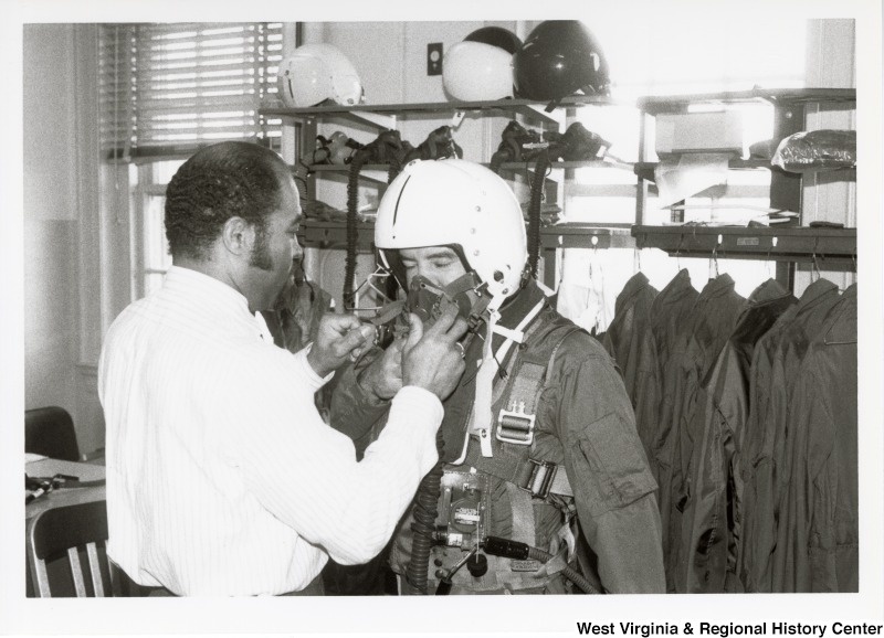 Unidentified man getting Congressman Nick Rahall ready to board a harrier jet at Marine Corps Base Quantico.