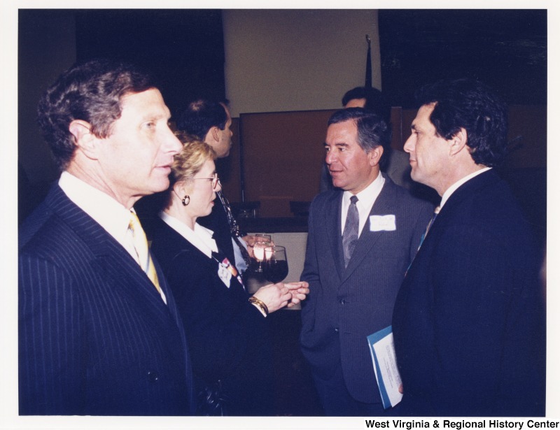 Congressman Nick Rahall (D-WV) speaking with three unidentified people at a social gathering.