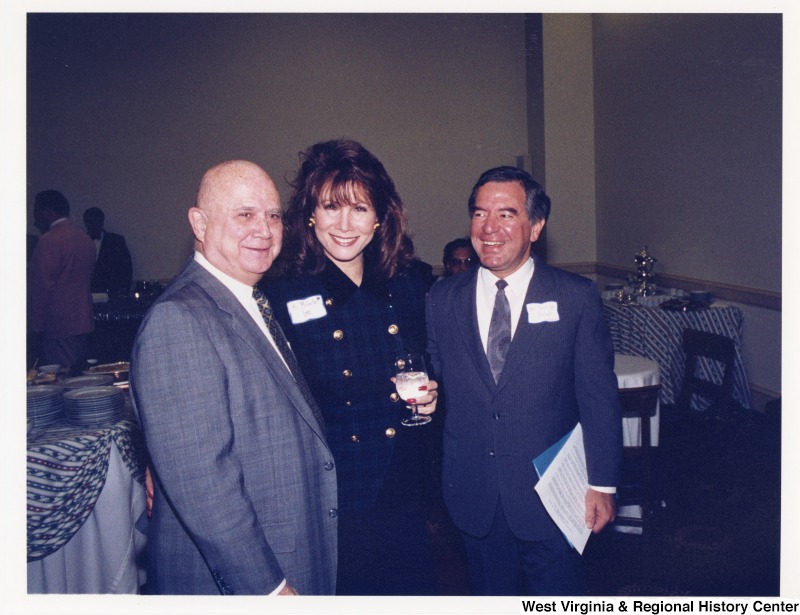 Congressman Nick Rahall (D-WV) with actress Michele Lee and an unidentified man at a social gathering.