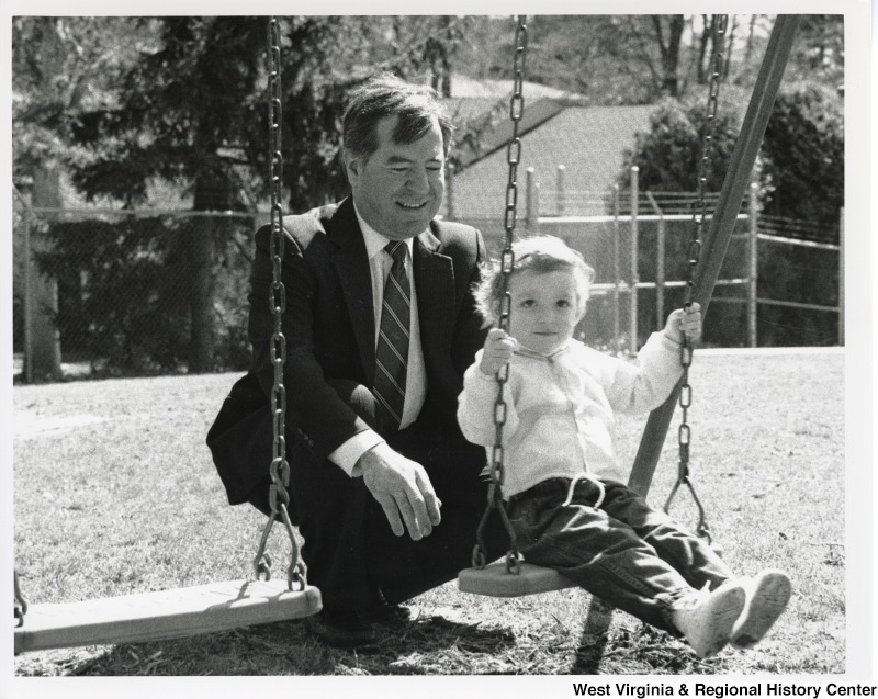 Congressman Nick Rahall (D-WV) pushing an unidentified girl on a swing.