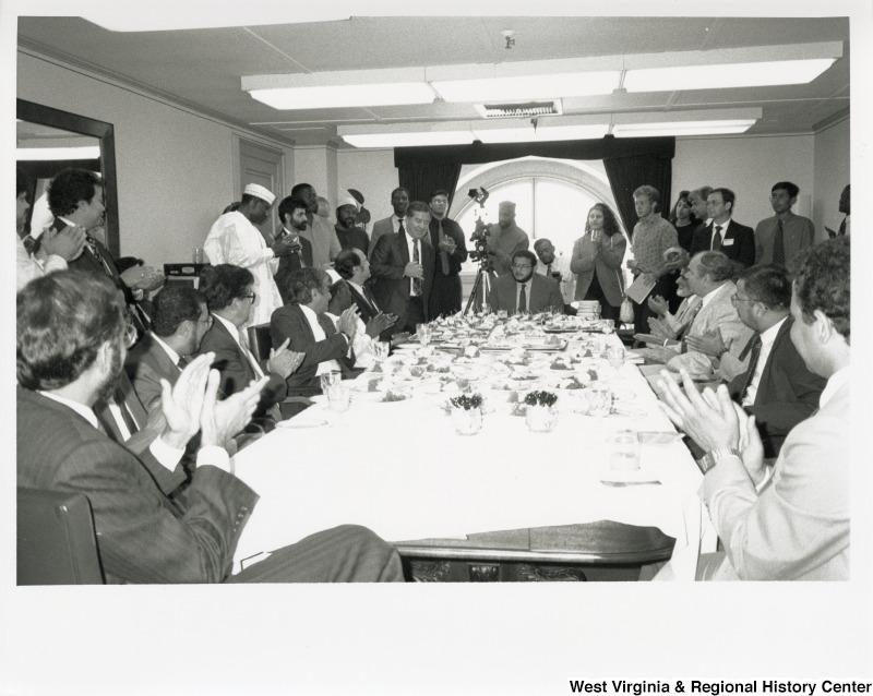 Congressman Nick Rahall (D-WV) standing during a reception with a large group of unidentified people.