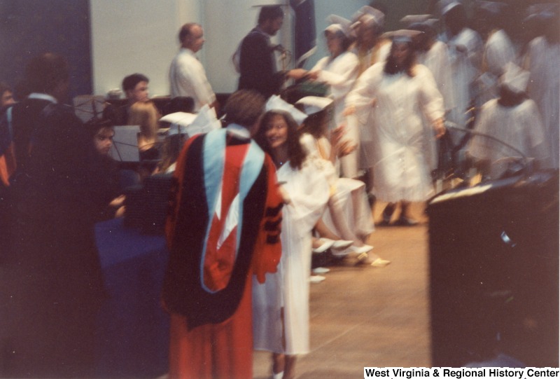 Rebecca Rahall walks across the stage to receive her diploma at her graduation ceremony.