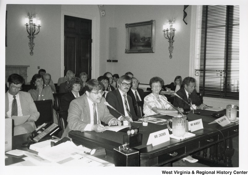 L-R: Mr. Zacher, Jim McNeel, Ms. Compton, unidentifiedThese four sit at a panel behind microphones in front of a crowd at the New River hearing.