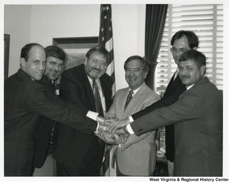 In the center, Representative Nick J. Rahall (D-W.Va.) shakes hands with a group of five unidentified men from the Matewan Revitalization Group.