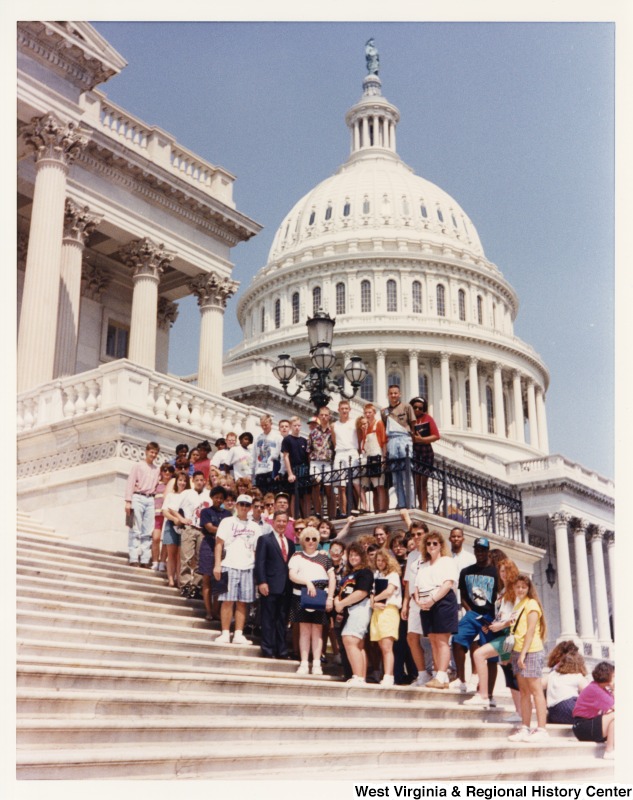 In the middle of the group, Representative Nick J. Rahall (D-W.Va.) stands for a photograph with a school group in front of the United States Capitol building.